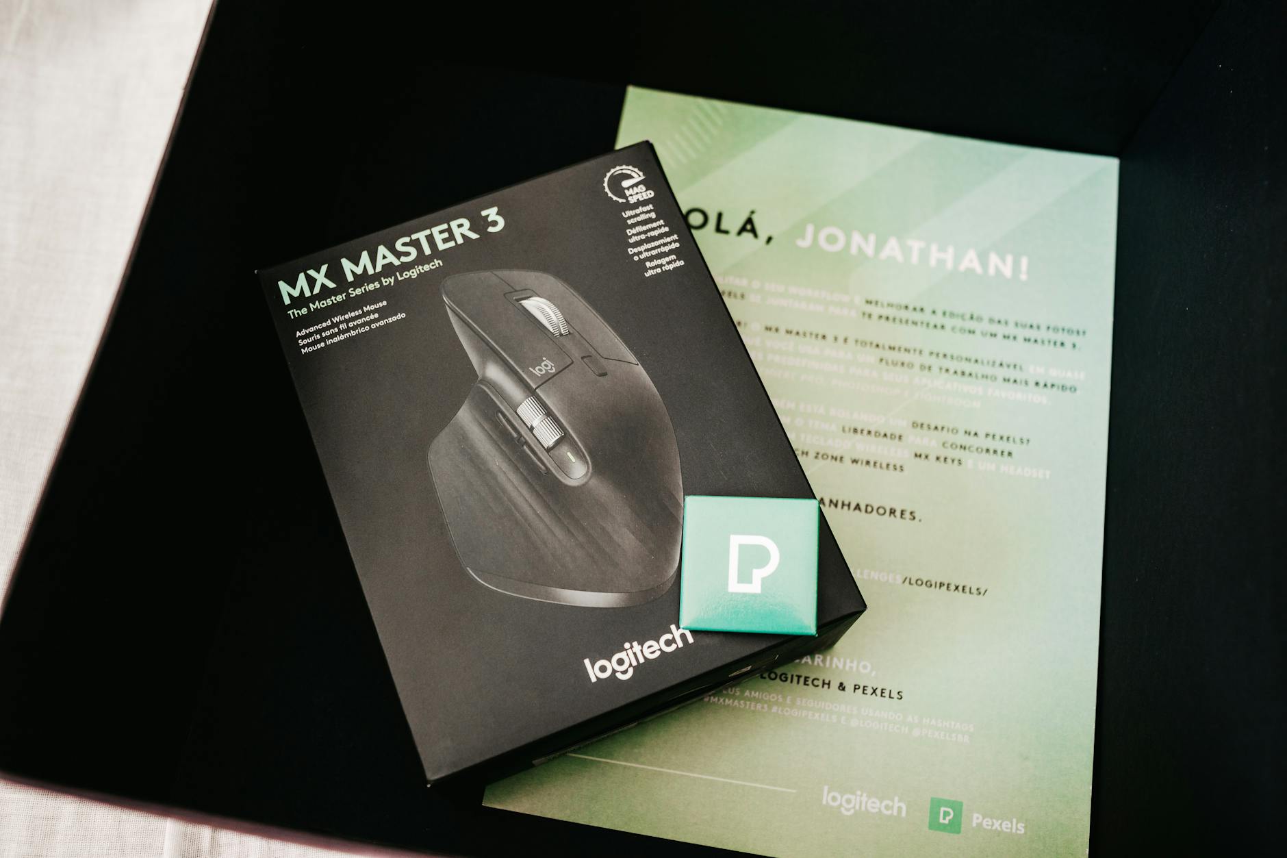 From above of black box with contemporary game mouse placed near personal certificate with name